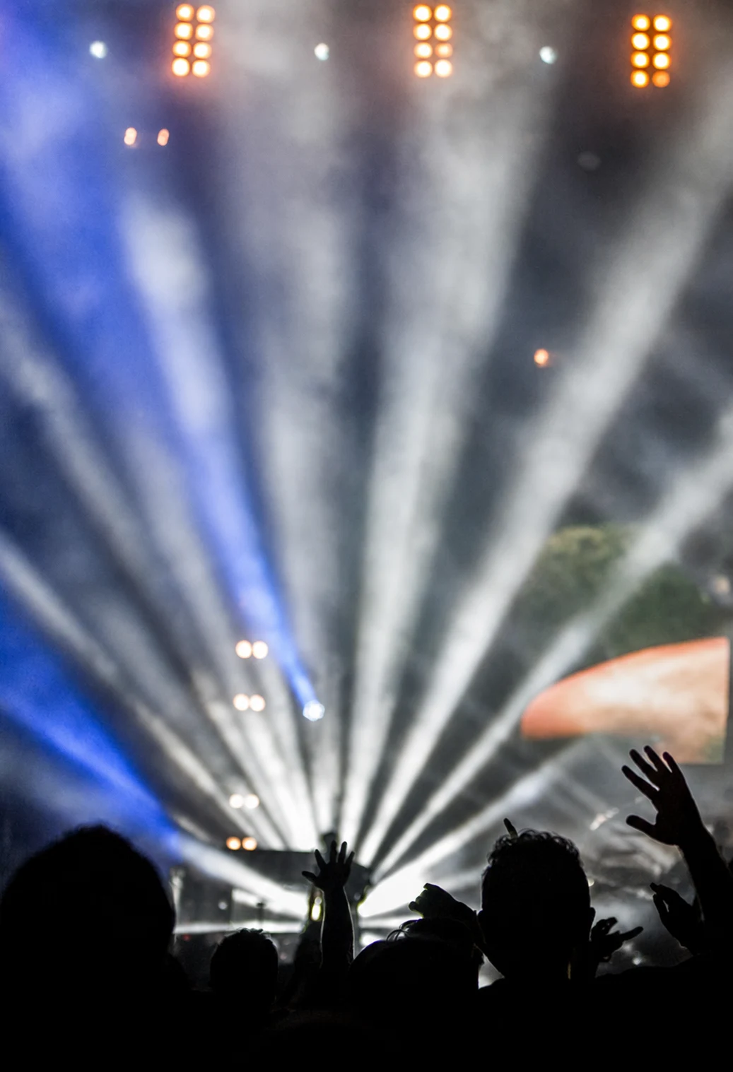 Haces de iluminación y público durante una producción en vivo